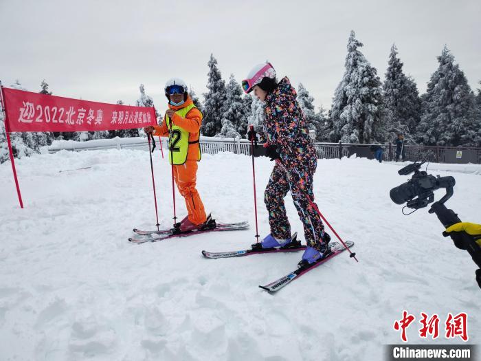 图为一名游客正在教练的指导下学习滑雪。　李韵涵 摄